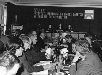 Grupa gości siedzi przy stole w trakcie uroczystych obchodów 20-lecia IBDiM.