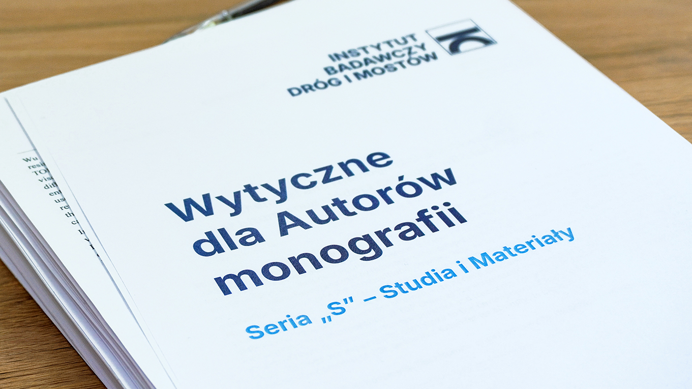 Zbliżenie na okładkę grubego wielostronicowego dokumentu, będącego papierową wersją wytycznych dla Autorów monografii, leży na biurku.